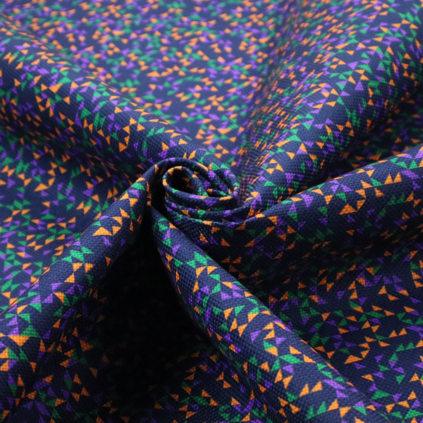 This fabric features a dense geometric pattern of tiny, randomly oriented triangles in shades of purple, green, and orange scattered across a solid dark navy blue background.