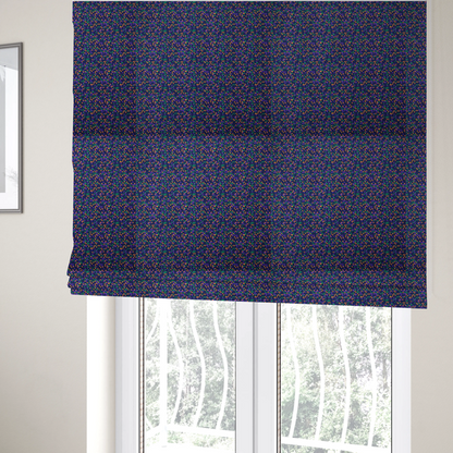 The fabric used to create these Roman blinds is a fabric features a dense geometric pattern of tiny, randomly oriented triangles in shades of purple, green, and orange scattered across a solid dark navy blue background.
