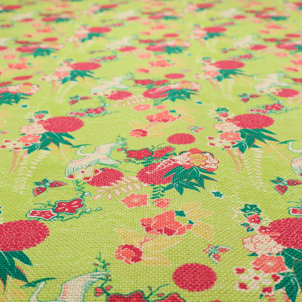 This fabric features a whimsical, Chinoiseries-inspired pattern on a bright chartreuse-green background, repeating illustrations of white cranes, large dark pink pom-pom flowers, and leafy green ferns.