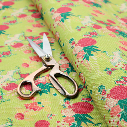 This fabric features a whimsical, Chinoiseries-inspired pattern on a bright chartreuse-green background, repeating illustrations of white cranes, large dark pink pom-pom flowers, and leafy green ferns.