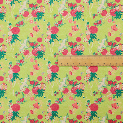 This fabric features a whimsical, Chinoiseries-inspired pattern on a bright chartreuse-green background, repeating illustrations of white cranes, large dark pink pom-pom flowers, and leafy green ferns.