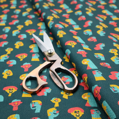 This fabric features a whimsical, repeating pattern on a dark teal background, decorated with stylized, colourful illustrations of diverse human faces in shades of bright yellow, light blue, and coral pink.
