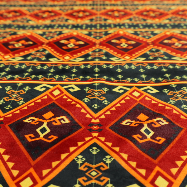 A fabric print featuring a repeating Southwestern geometric pattern. The design consists of horizontal bands with large red, orange, and yellow diamond motifs mixed with thin charcoal black borders detailed with small, delicate yellow tribal symbols.