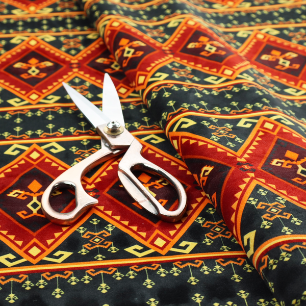 A fabric print featuring a repeating Southwestern geometric pattern. The design consists of horizontal bands with large red, orange, and yellow diamond motifs mixed with thin charcoal black borders detailed with small, delicate yellow tribal symbols.
