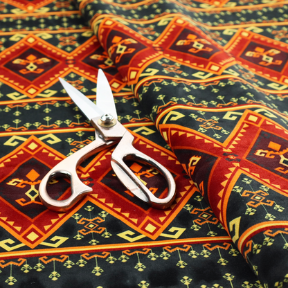 A fabric print featuring a repeating Southwestern geometric pattern. The design consists of horizontal bands with large red, orange, and yellow diamond motifs mixed with thin charcoal black borders detailed with small, delicate yellow tribal symbols.