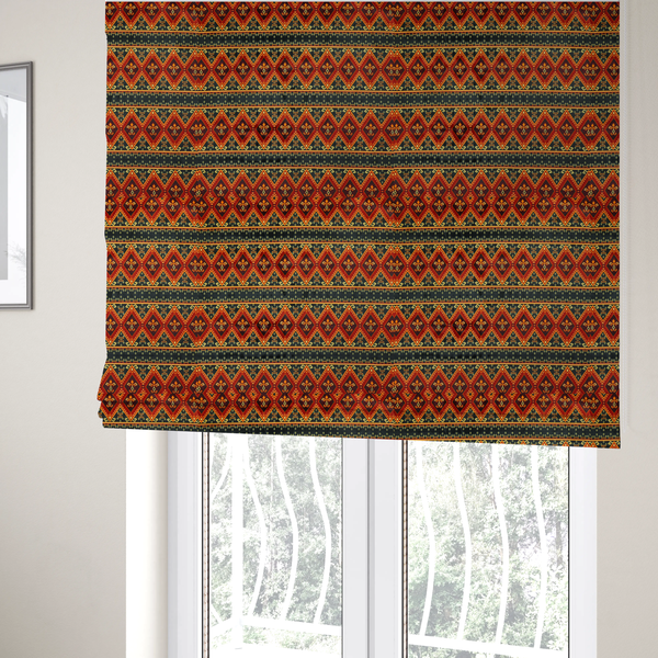 The fabric used to create these Roman blinds is a fabric print featuring a repeating Southwestern geometric pattern. The design consists of horizontal bands with large red, orange, and yellow diamond motifs mixed with thin charcoal black borders detailed with small, delicate yellow tribal symbols.