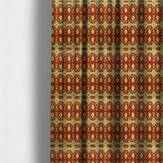 the fabric used to create these made-to-measure curtains is a print featuring a repeating vertical ikat pattern. The design showcases distinct diamond and teardrop motifs with feathered edges in soft sage green, teal, and mustard yellow over a solid terracotta red background.