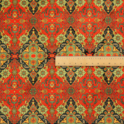 Fabric print featuring an intricate, repeating Persian rug or Moroccan mosaic design. The pattern displays large geometric medallions and scrolling damask shapes in vibrant red, jade green, and warm gold.