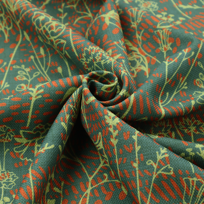 Fabric print featuring a whimsical wildflower meadow pattern. The design showcases delicate lime-green line art sketches of slender stems and blossoms over a deep teal-green background layered with small, textured terracotta orange dashes.