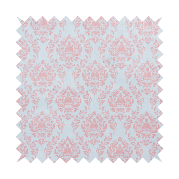 Fabric print featuring a classic, repeating vintage damask pattern. The traditional ornate floral and acanthus leaf motifs are printed in a soft blush pink over a light, pastel icy blue background.