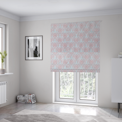 The fabric used to create these Roman blinds is a print featuring a classic, repeating vintage damask pattern. The traditional ornate floral and acanthus leaf motifs are printed in a soft blush pink over a light, pastel icy blue background.