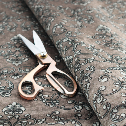 Fabric featuring a repeating traditional damask pattern in white and dark grey outlines over a textured, light taupe background.