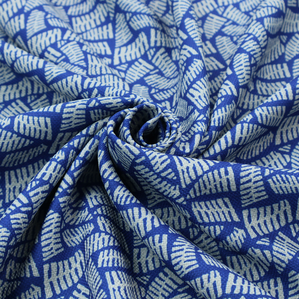 Fabric featuring a vibrant, repeating geometric pattern of light grey, abstract leaf or comb-like blocks closely packed on a royal blue background.