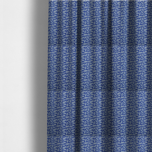 The fabric used to create these made-to-measure curtains is featuring a vibrant, repeating geometric pattern of light grey, abstract leaf or comb-like blocks closely packed on a royal blue background.