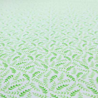 Fabric featuring a dense, repeating pattern of small, vibrant lime green leafy sprigs and fern-like fronds on a crisp white background.
