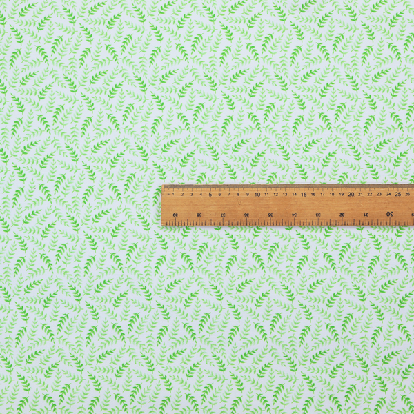 Fabric featuring a dense, repeating pattern of small, vibrant lime green leafy sprigs and fern-like fronds on a crisp white background.