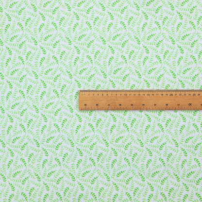 Fabric featuring a dense, repeating pattern of small, vibrant lime green leafy sprigs and fern-like fronds on a crisp white background.