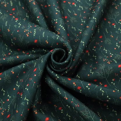 Dark forest green fabric featuring a delicate, scattered botanical print. The pattern includes fine, wispy light green twigs, tiny light green leaves, and small, vibrant red wildflowers and buds spread evenly across the textured dark background.