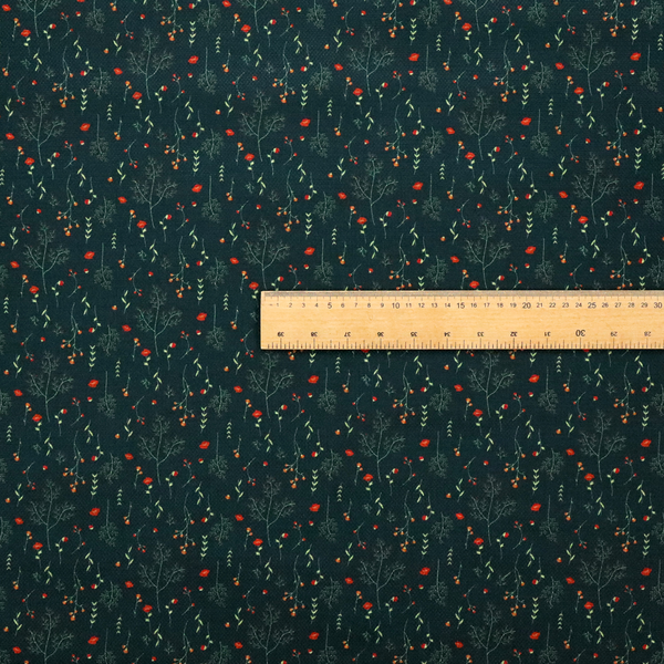 Dark forest green fabric featuring a delicate, scattered botanical print. The pattern includes fine, wispy light green twigs, tiny light green leaves, and small, vibrant red wildflowers and buds spread evenly across the textured dark background.