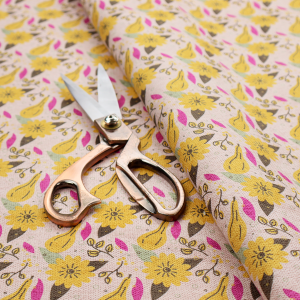 Light pink textured fabric with a dense retro pattern featuring mustard yellow sunflowers and pears. The design includes small sage green leaves, dark line-art twigs, and vibrant fuchsia pink leaf accents repeated seamlessly throughout the textile (Pattern DP-592-1).