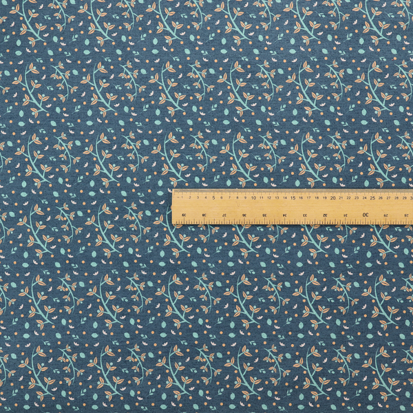 Slate blue textured fabric with a delicate ditsy botanical print. The repeating pattern features thin, curved mint green vine stems with small peach-coloured leaves, surrounded by tiny scattered peach polka dots and miniature teal leaf accents throughout the design.