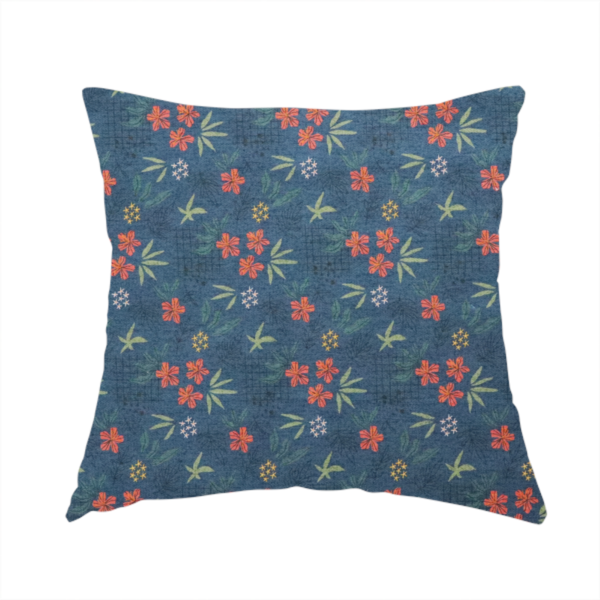 The fabric used to create this handmade cushion is a deep teal blue fabric featuring a subtle crosshatch texture and a tropical botanical print. The repeating pattern showcases clusters of small rust-coral flowers, sage green palm fronds, and scattered miniature yellow starburst blooms.