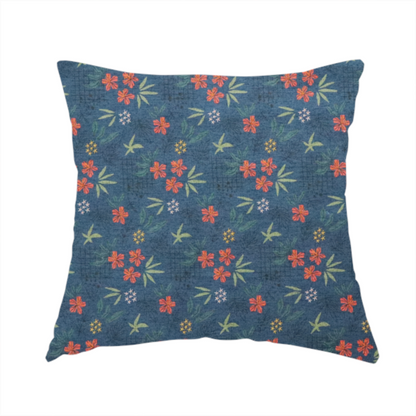 The fabric used to create this handmade cushion is a deep teal blue fabric featuring a subtle crosshatch texture and a tropical botanical print. The repeating pattern showcases clusters of small rust-coral flowers, sage green palm fronds, and scattered miniature yellow starburst blooms.