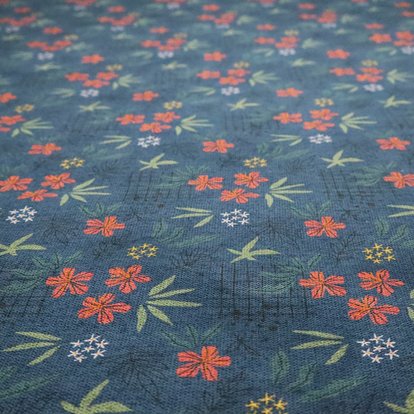 Deep teal blue fabric featuring a subtle crosshatch texture and a tropical botanical print. The repeating pattern showcases clusters of small rust-coral flowers, sage green palm fronds, and scattered miniature yellow starburst blooms.