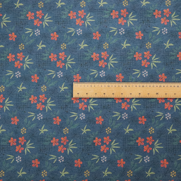 Deep teal blue fabric featuring a subtle crosshatch texture and a tropical botanical print. The repeating pattern showcases clusters of small rust-coral flowers, sage green palm fronds, and scattered miniature yellow starburst blooms.