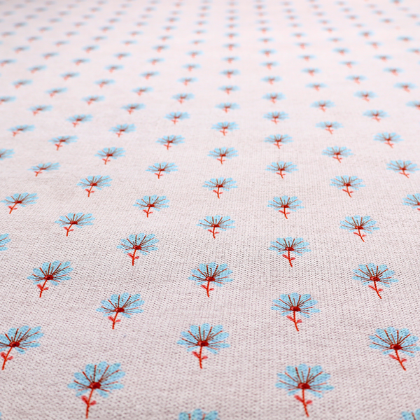 Light pink textured canvas fabric featuring a dainty, minimalist ditsy floral print. The pattern consists of neat, repeating rows of tiny cornflower blue wildflowers with slender reddish-brown stems spread evenly across the soft pastel background.