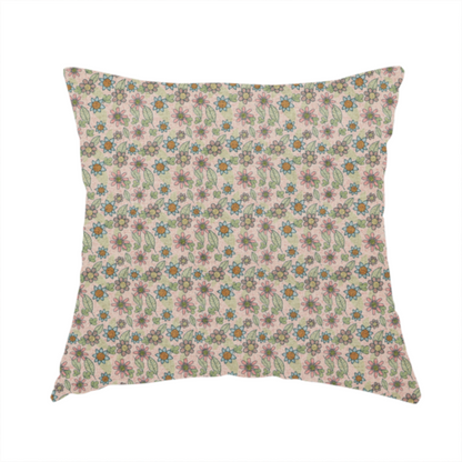 The fabric used to create this handmade cushion is a textured dusty blush pink fabric with a dense retro calico print. The intricate pattern features small, sketch-style daisies with mustard yellow centres and blue-teal petals, mixed with pink blooms and delicate sage green leaves spread tightly across the surface.