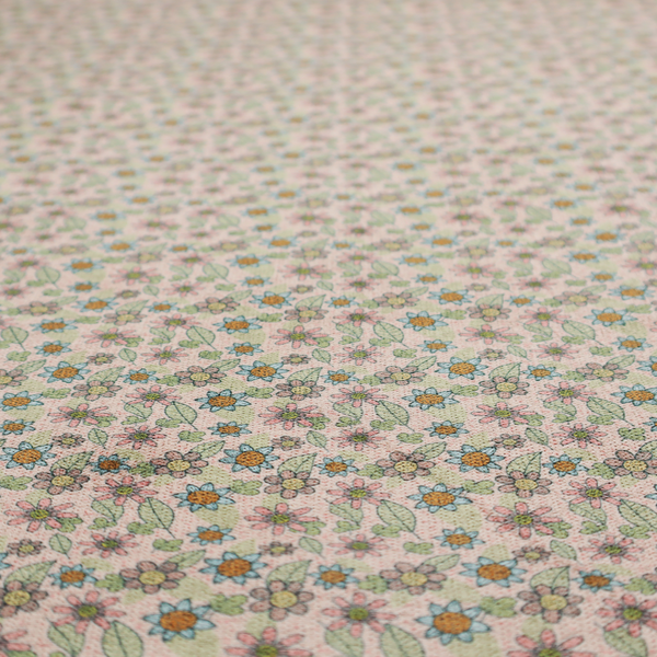 Textured dusty blush pink fabric with a dense retro calico print. The intricate pattern features small, sketch-style daisies with mustard yellow centres and blue-teal petals, mixed with pink blooms and delicate sage green leaves spread tightly across the surface.