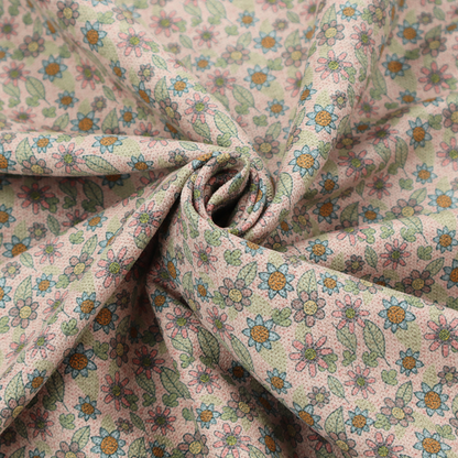 Textured dusty blush pink fabric with a dense retro calico print. The intricate pattern features small, sketch-style daisies with mustard yellow centres and blue-teal petals, mixed with pink blooms and delicate sage green leaves spread tightly across the surface.