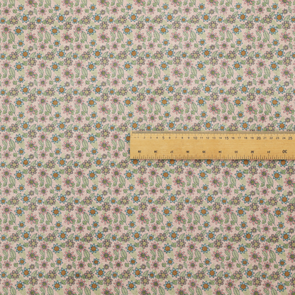Textured dusty blush pink fabric with a dense retro calico print. The intricate pattern features small, sketch-style daisies with mustard yellow centres and blue-teal petals, mixed with pink blooms and delicate sage green leaves spread tightly across the surface.