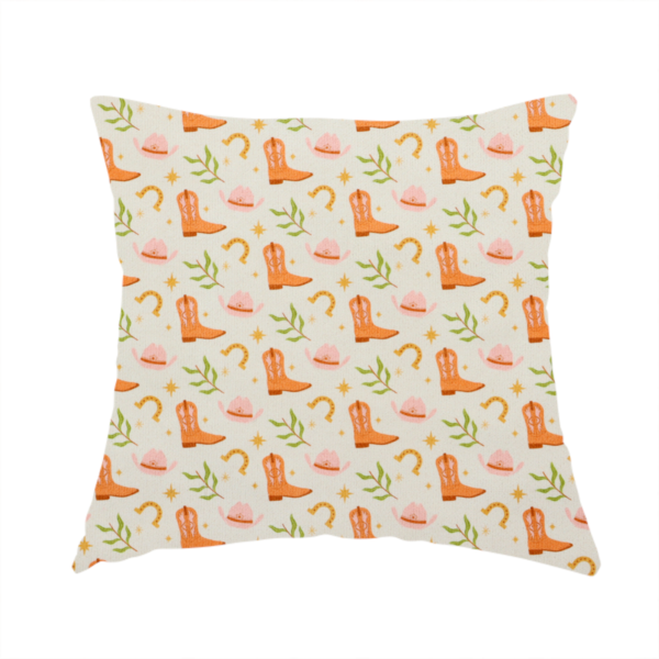 The fabric used to create this handmade cushion is a repeating pattern of cowboy-themed illustrations on a cream-coloured fabric backdrop. The design features light orange cowboy boots, pale pink cowboy hats, golden horseshoes, small green leafy sprigs, and delicate four-pointed stars scattered throughout.