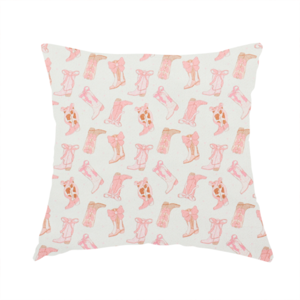 The fabric used to create this handmade cushion is a repeating seamless pattern featuring an assortment of illustrated cowboy and cowgirl boots against a clean, off-white background. The boots are rendered in a soft, whimsical style with a colour palette consisting of various shades of pink, cream, light tan, and occasional brown accents.