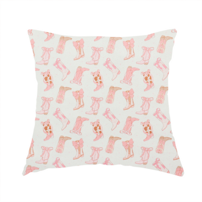 The fabric used to create this handmade cushion is a repeating seamless pattern featuring an assortment of illustrated cowboy and cowgirl boots against a clean, off-white background. The boots are rendered in a soft, whimsical style with a colour palette consisting of various shades of pink, cream, light tan, and occasional brown accents.