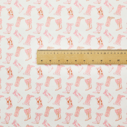 A repeating seamless pattern featuring an assortment of illustrated cowboy and cowgirl boots against a clean, off-white background. The boots are rendered in a soft, whimsical style with a colour palette consisting of various shades of pink, cream, light tan, and occasional brown accents.