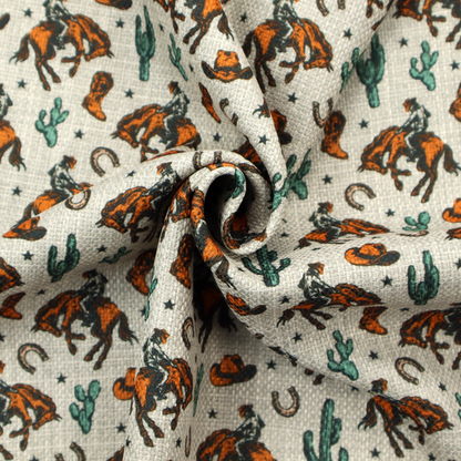 A seamless, repeating pattern featuring traditional western motifs in a classic comic or illustration style, set against a textured, light oatmeal or linen-look background. The colour palette relies heavily on bold terracotta orange, deep teal green, and dark brown accents.