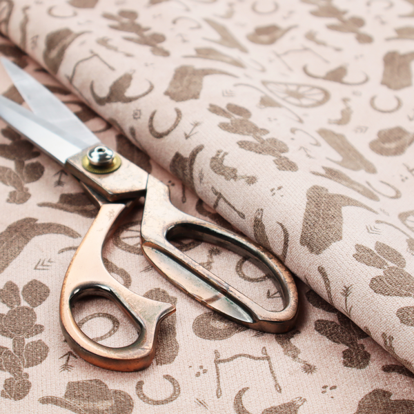 A repeating toile-style western pattern featuring classic cowboy motifs printed in a monochromatic, textured medium-brown hue against a light beige background.