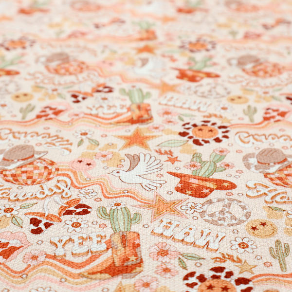 A vibrant, repeating pattern blending 1970s retro elements with a western aesthetic, set against a light cream-colored background. The design uses a warm colour palette of terracotta orange, muted mustard yellow, sage green, and soft tan.