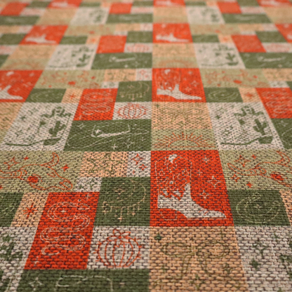 A repeating geometric patchwork pattern featuring western motifs framed inside distinct rectangular and square tiles. The design is printed on a heavily woven, textured linen-look fabric base. The Earth-toned colour palette consists of rich terracotta orange, olive green, muted sage, and warm cream.