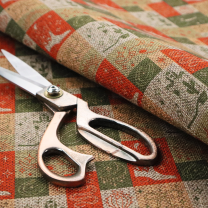 A repeating geometric patchwork pattern featuring western motifs framed inside distinct rectangular and square tiles. The design is printed on a heavily woven, textured linen-look fabric base. The Earth-toned colour palette consists of rich terracotta orange, olive green, muted sage, and warm cream.
