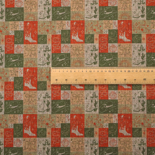 A repeating geometric patchwork pattern featuring western motifs framed inside distinct rectangular and square tiles. The design is printed on a heavily woven, textured linen-look fabric base. The Earth-toned colour palette consists of rich terracotta orange, olive green, muted sage, and warm cream.