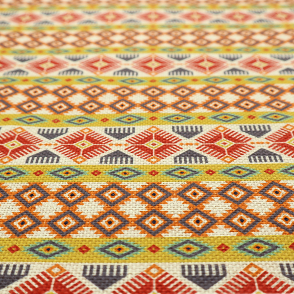 A vibrant, multi-coloured southwestern stripe pattern featuring repeating horizontal bands of geometric, tribal-inspired motifs. The detailed design is printed on a textured, linen-look cream fabric background, utilizing a bold colour palette of mustard yellow, terracotta red, slate blue-grey, and rust orange.