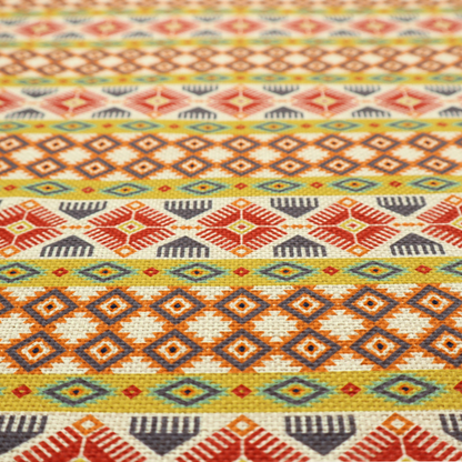 A vibrant, multi-coloured southwestern stripe pattern featuring repeating horizontal bands of geometric, tribal-inspired motifs. The detailed design is printed on a textured, linen-look cream fabric background, utilizing a bold colour palette of mustard yellow, terracotta red, slate blue-grey, and rust orange.