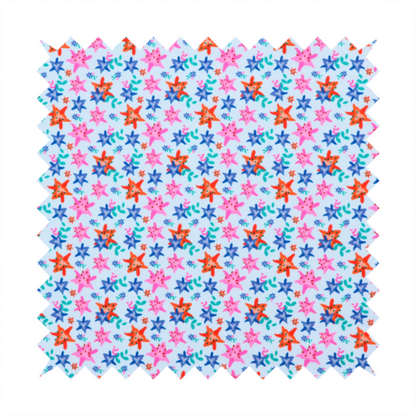 A dense, small-scale tropical ditsy pattern. The design consists of repeating star-shaped lily blossoms in bright shades of orange, magenta pink, and medium blue, accented with tiny teal green leafy sprigs and miniature blue flowers, all distributed across a solid light sky-blue background.