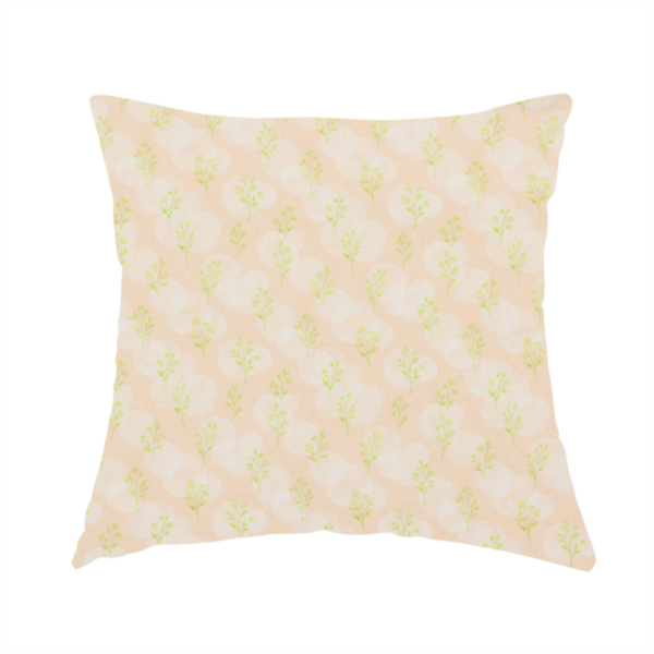 The fabric used to create this handmade cushion is a soft watercolour design. The background consists of a subtle pastel peach wash layered with faint, painterly off-white circular polka dots. Arranged in neat diagonal rows over the circles are miniature, light lime green botanical sprigs and fine leaf stems.