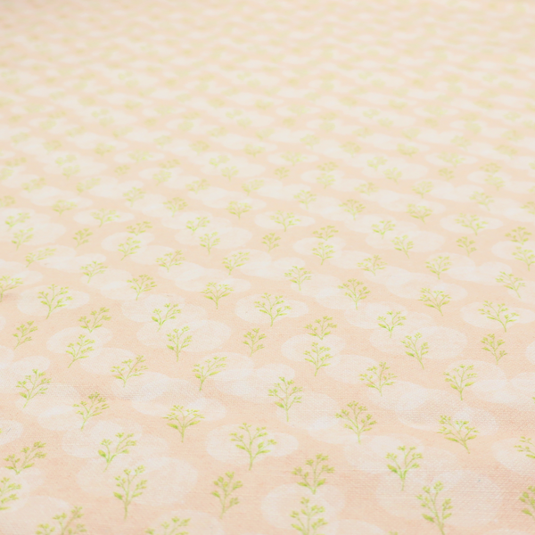 A soft watercolour design. The background consists of a subtle pastel peach wash layered with faint, painterly off-white circular polka dots. Arranged in neat diagonal rows over the circles are miniature, light lime green botanical sprigs and fine leaf stems.