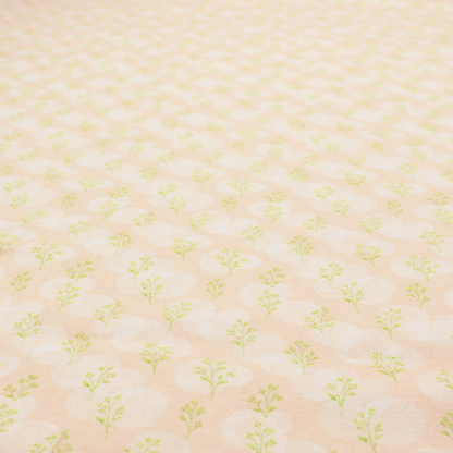 A soft watercolour design. The background consists of a subtle pastel peach wash layered with faint, painterly off-white circular polka dots. Arranged in neat diagonal rows over the circles are miniature, light lime green botanical sprigs and fine leaf stems.